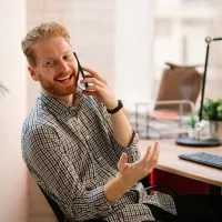 Young,Businessman,Using,Phone,In,The,Office